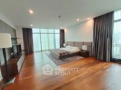 Spacious modern bedroom with floor-to-ceiling windows and elegant hardwood flooring.