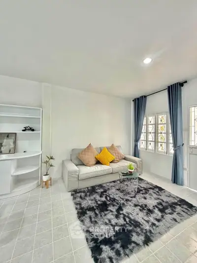 Bright living room with modern decor, cozy sofa, and stylish rug, perfect for relaxation and entertaining.