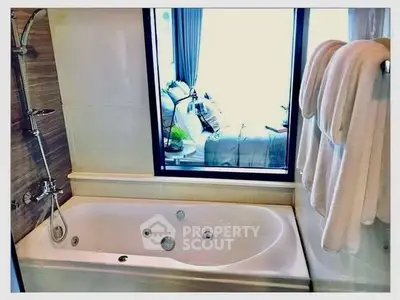 Luxurious bathroom with a modern bathtub and window view, perfect for relaxation.