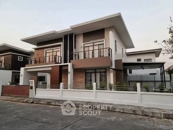 Modern two-story house with sleek design and spacious balcony in a suburban neighborhood.