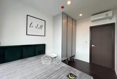 Modern bedroom with sleek design, featuring a stylish bed, built-in wardrobe, and air conditioning.