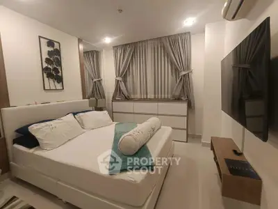 Modern bedroom with sleek design, featuring a comfortable bed, stylish curtains, and a wall-mounted TV.