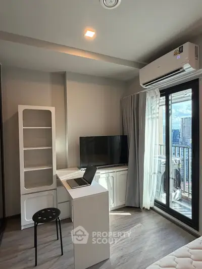Modern living room with balcony view, featuring sleek furniture and natural light.