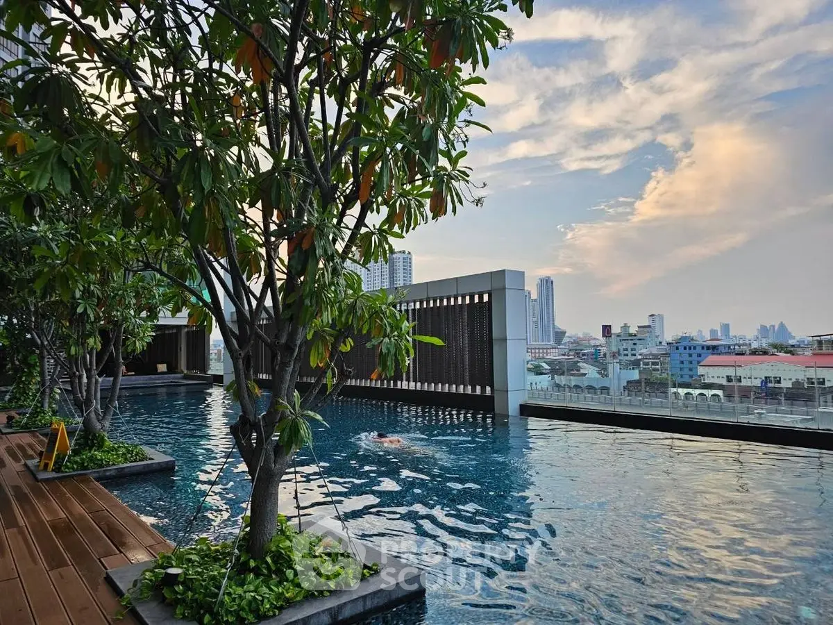 Luxurious rooftop pool with stunning city skyline view and lush greenery.