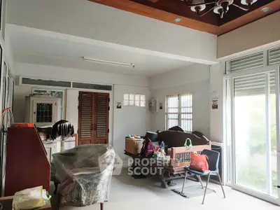 Spacious living room with wooden furniture and large windows for natural light.