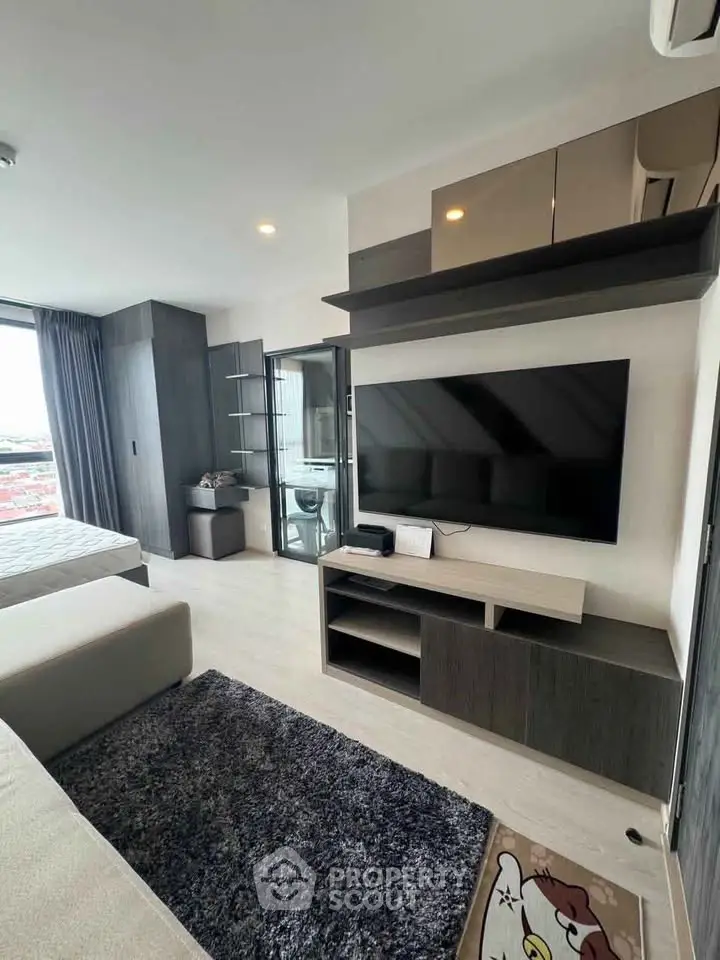 Modern living room with sleek TV setup and stylish decor in a contemporary apartment.
