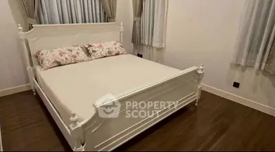 Cozy bedroom with elegant white bed and floral pillows, perfect for relaxation.