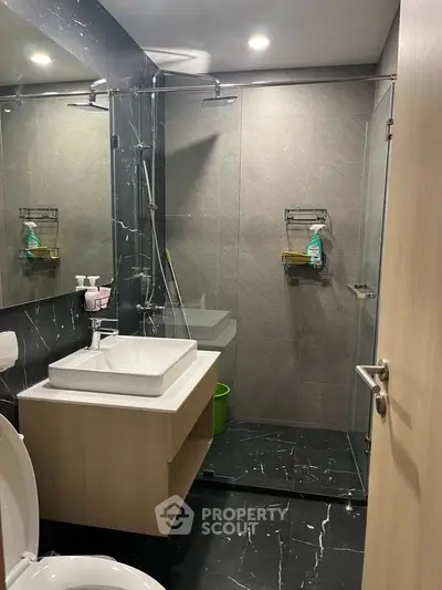 Modern bathroom with sleek design, glass shower, and stylish fixtures in a contemporary apartment.
