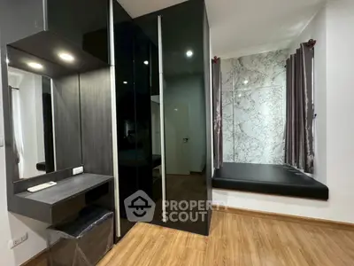 Modern bedroom with sleek black wardrobe and cozy window seating area.