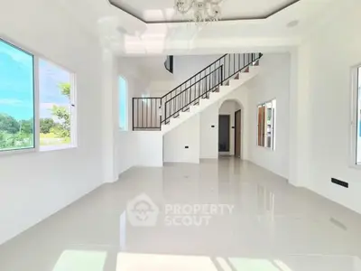 Spacious modern living room with high ceiling and elegant staircase