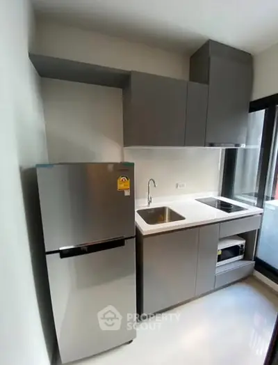 Modern kitchen with sleek cabinetry and stainless steel appliances in a compact layout.