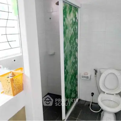 Compact bathroom with shower and modern fixtures in bright white tiles.