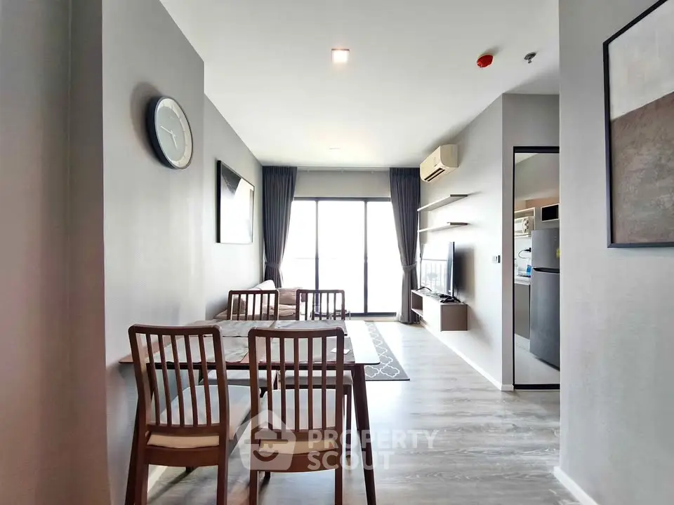 Modern living room with dining area and balcony access in a stylish apartment.