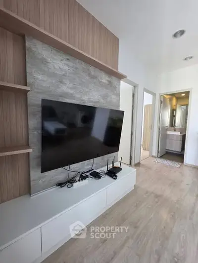 Modern living room with sleek TV setup and stylish wooden accents