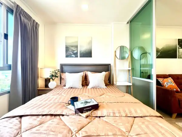 Cozy bedroom with stylish decor and natural light, perfect for relaxation.