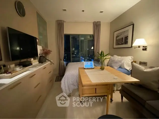 Cozy studio apartment with modern decor and city view, featuring a compact living area and bedroom.