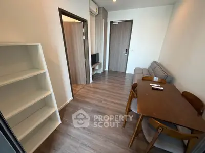 Modern living room with wooden flooring, cozy sofa, and dining table in a stylish apartment.