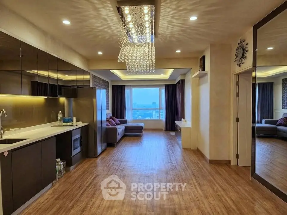Luxurious open-plan living room with modern kitchen and stunning city view.