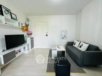 Modern living room with sleek furniture and stylish decor, featuring a TV and cozy seating area.