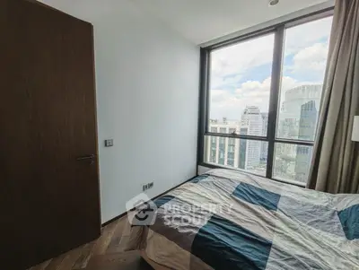 Modern bedroom with large window offering stunning city view in high-rise apartment.