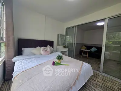 Bright and cozy bedroom with large windows and modern decor, perfect for relaxation.