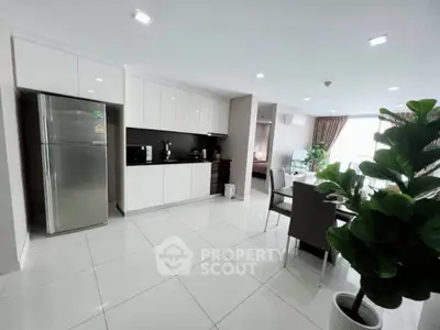 Modern open-layout kitchen with sleek appliances and dining area in a bright, spacious apartment.