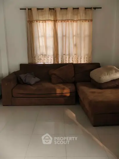 Cozy living room with brown sectional sofa and soft lighting