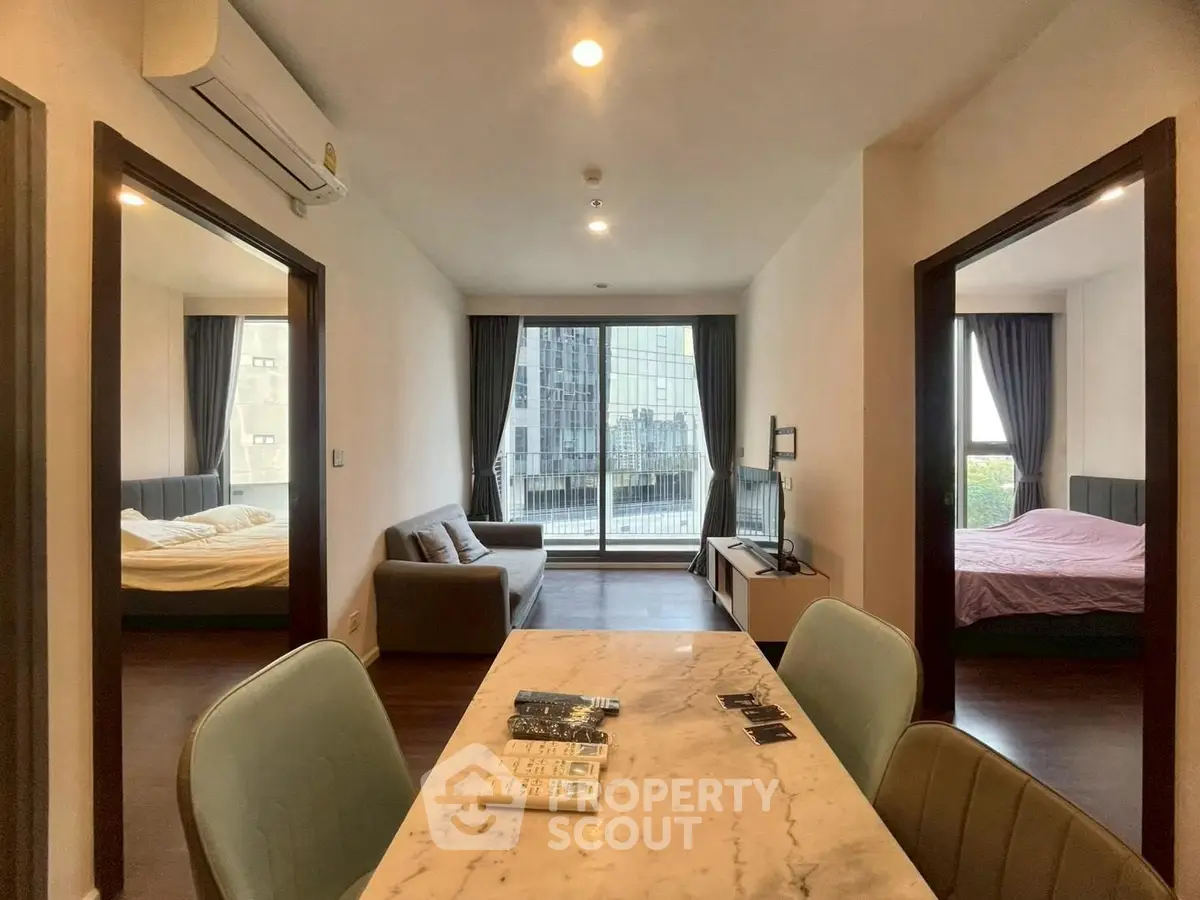Modern apartment interior with two bedrooms and a spacious living area featuring a city view.