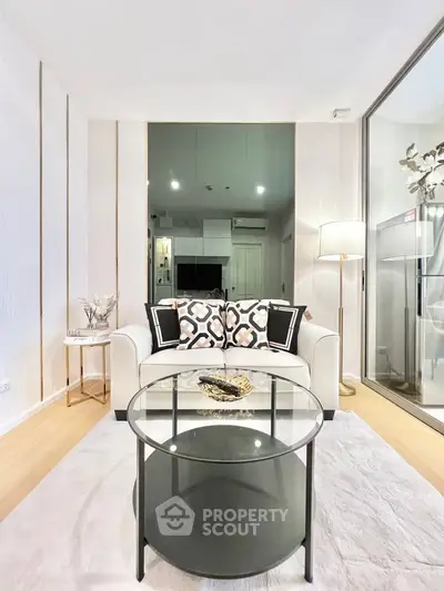 Modern living room with stylish decor and glass coffee table in a cozy apartment.