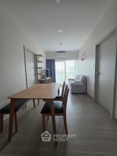 Modern living room with dining area and natural light in a stylish apartment.