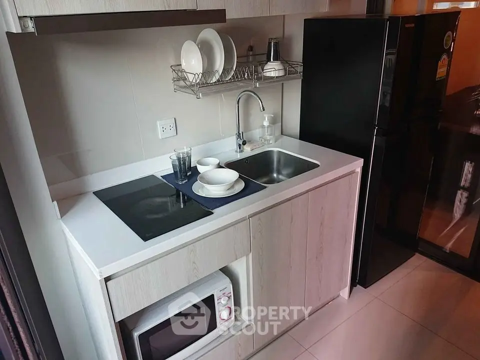 Modern compact kitchen with sleek appliances and efficient storage solutions.