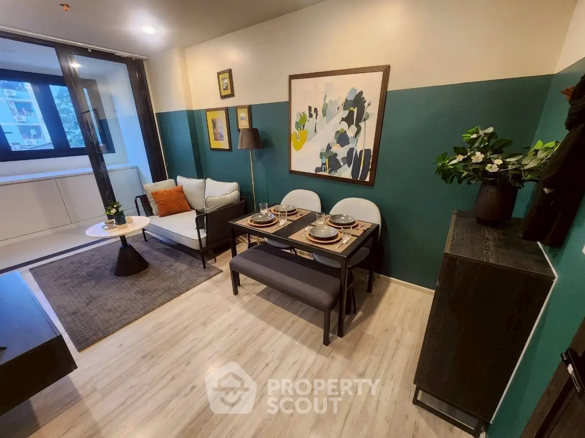 Modern living room with stylish decor and dining area, featuring elegant furniture and vibrant artwork.