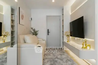 Modern living room with sleek design, featuring a large TV, elegant decor, and cozy seating area.