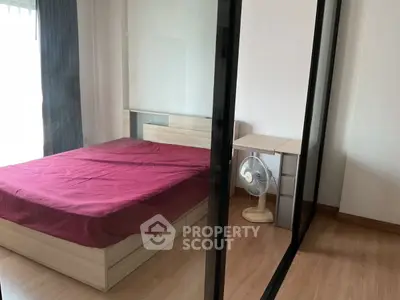 Modern bedroom with glass partition and wooden furniture, featuring a cozy bed and fan.