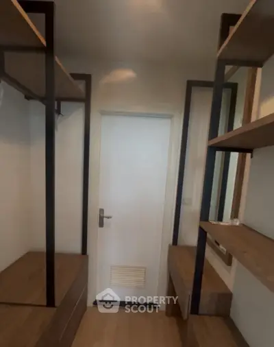 Spacious walk-in closet with modern shelving and wooden flooring.