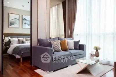 Modern living room with cozy sofa and elegant decor adjacent to a stylish bedroom.