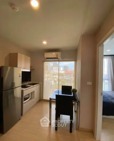 Modern compact kitchen with dining area and view of bedroom in cozy apartment