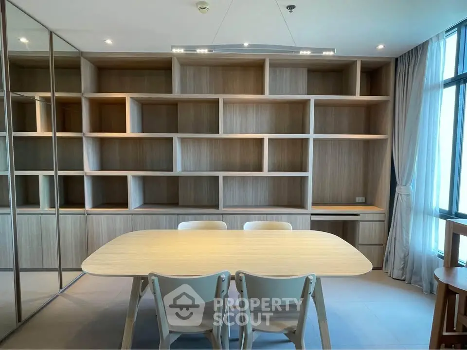 Modern dining area with wooden table and built-in shelving