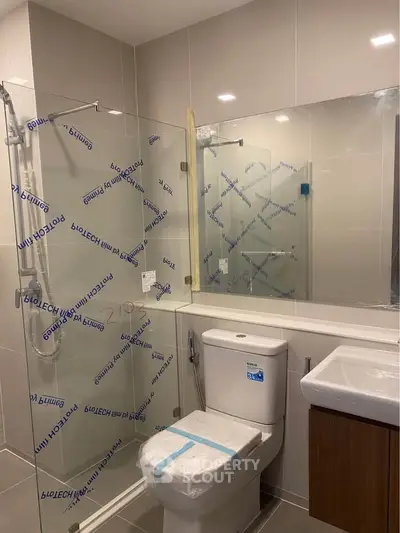 Modern bathroom with glass shower enclosure and sleek fixtures