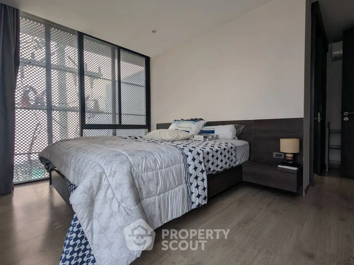 Modern bedroom with stylish decor and large window for natural light