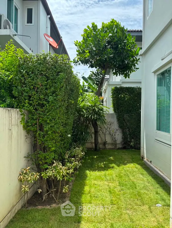 Charming garden view of a modern townhouse with lush greenery and well-maintained lawn.