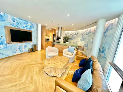 Luxurious living room with modern decor and large TV, featuring stylish furniture and unique wall design.