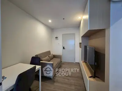 Modern living room with sleek furniture and wall-mounted TV in a cozy apartment.