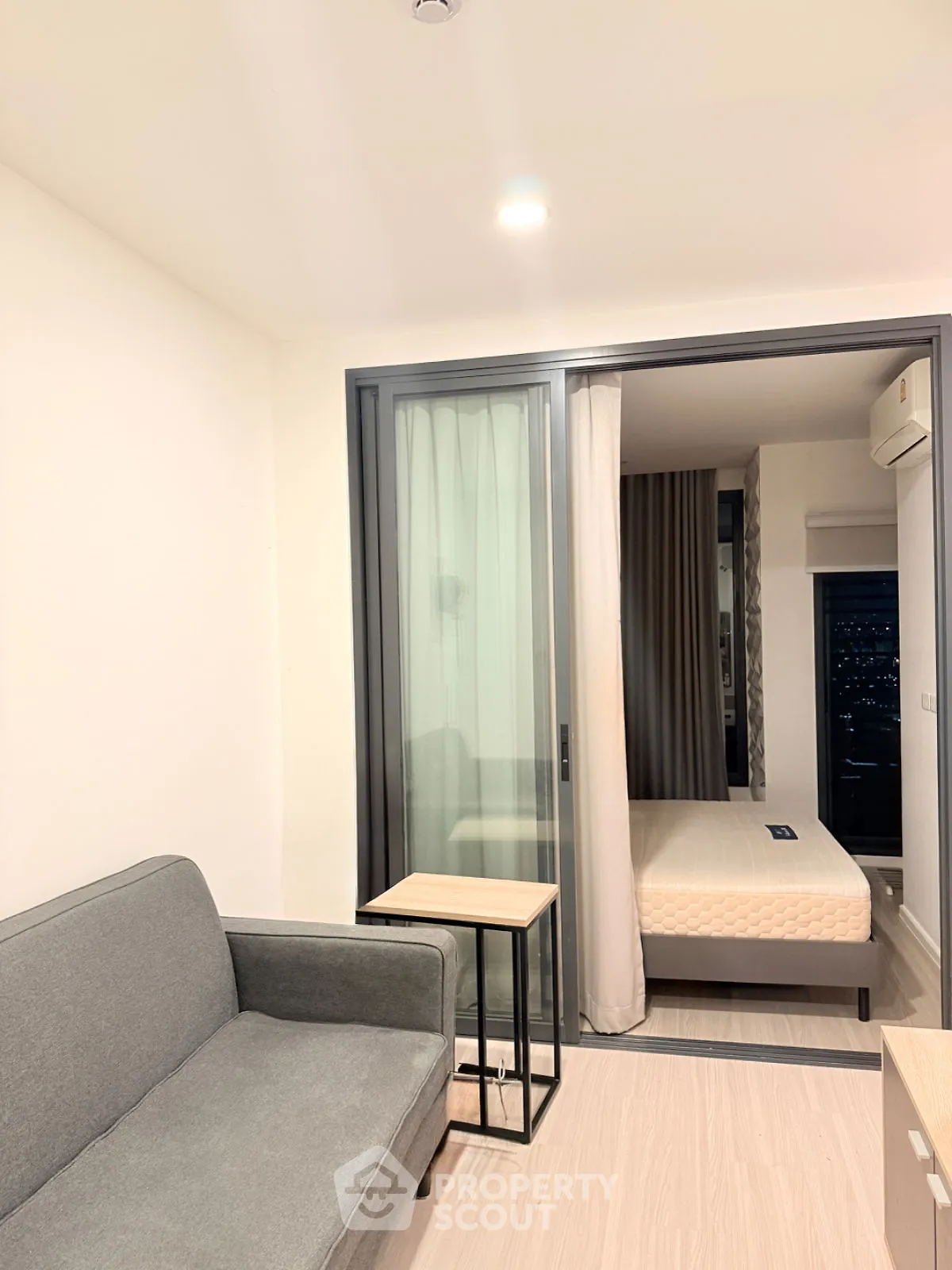 Modern apartment interior with cozy living area and bedroom view.