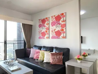 Stylish living room with modern decor and vibrant artwork in a high-rise apartment.