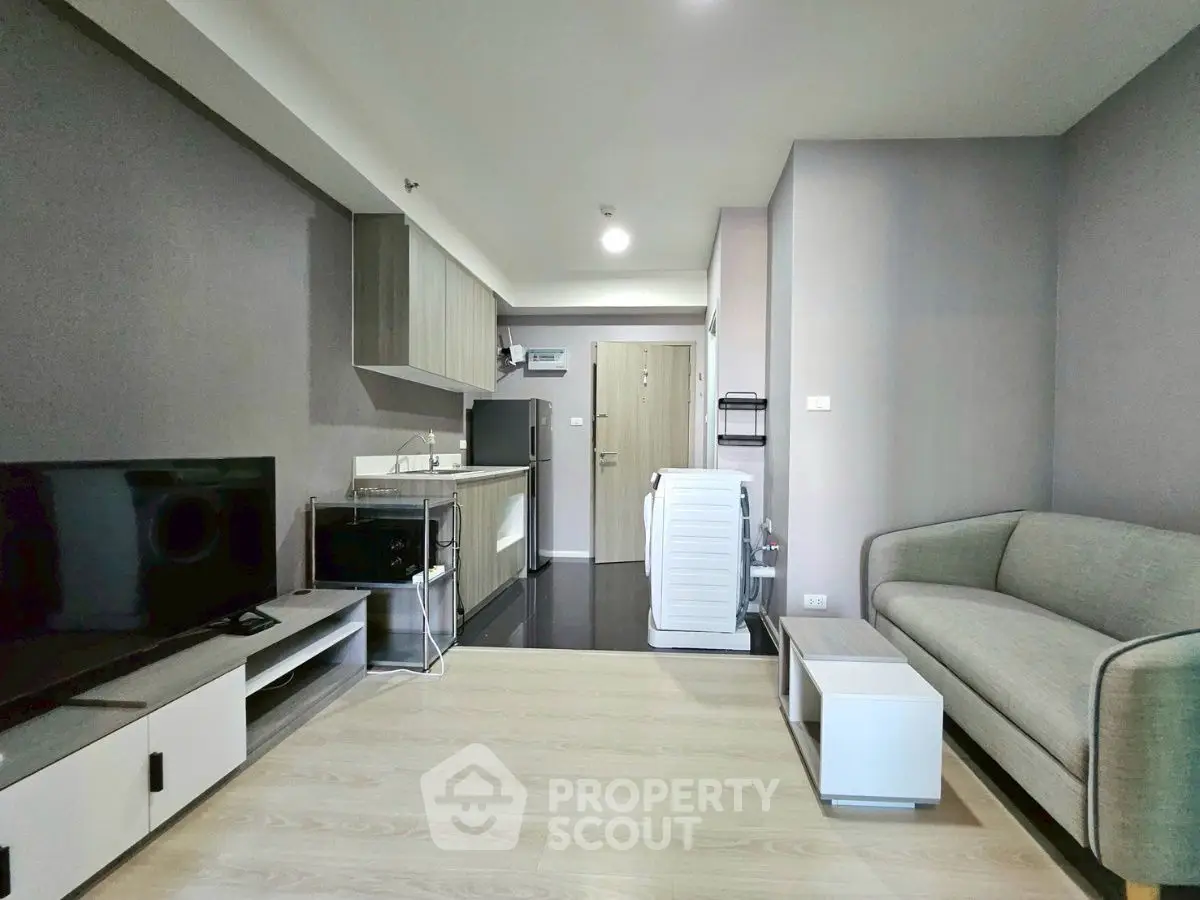 Modern living room with sleek furniture and integrated kitchen in open layout apartment.