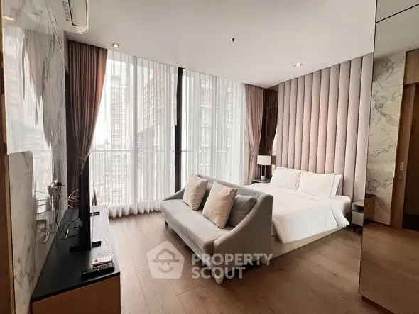 Luxurious modern bedroom with floor-to-ceiling windows and elegant decor in high-rise apartment.