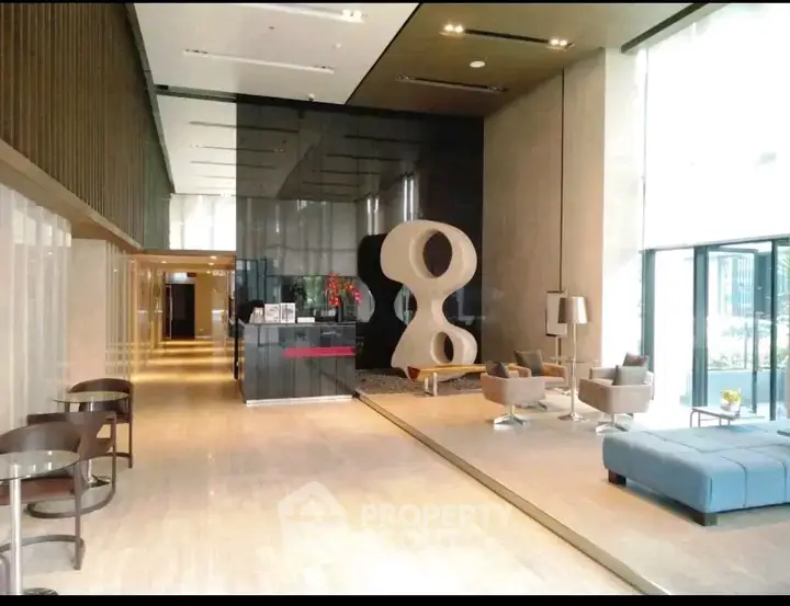 Luxurious modern lobby with stylish seating and unique sculpture in upscale building.