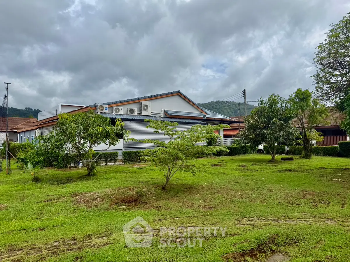 Charming suburban home with lush green lawn and mature trees, perfect for family living.