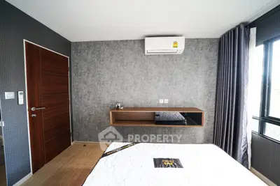 Modern bedroom with stylish gray accent wall and air conditioning unit.